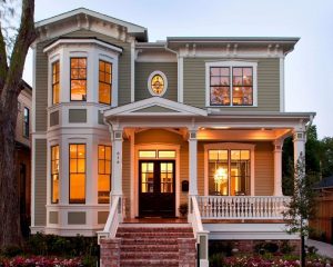 Two-story house with two sets of bay windows plus other windows styles, front porch, double front doors, olive green siding